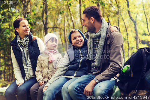 Image of happy family sitting on bench and talking at camp