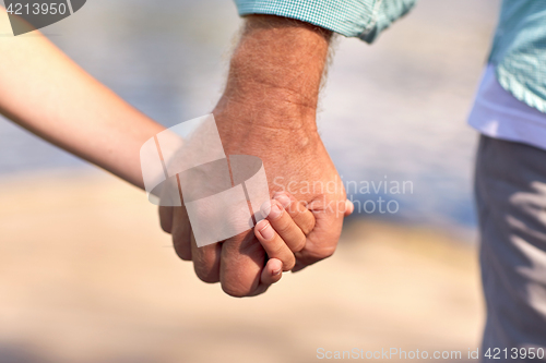 Image of senior man and child holding hands