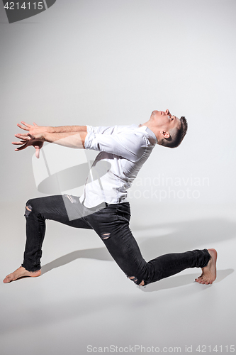 Image of The young man dancing on gray