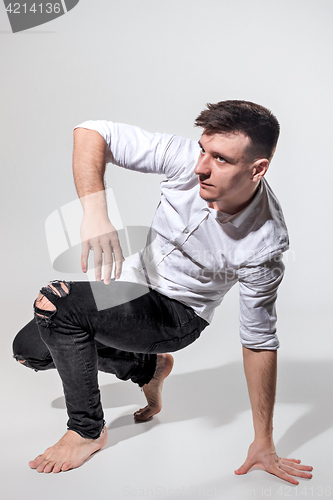 Image of The young man dancing on gray