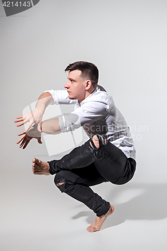 Image of The young man dancing on gray