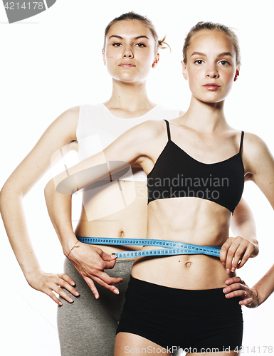 Image of two sport girls measuring themselves isolated on white