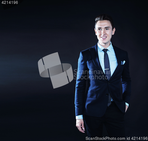 Image of young pretty business man standing on black background, modern h