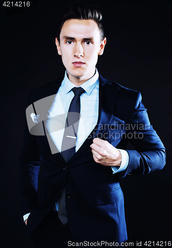 Image of young pretty business man standing on black background, modern h