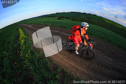 Image of Tourist with backpack travels by bicycle