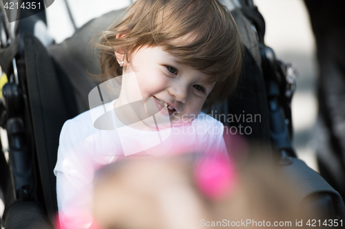 Image of baby girl sitting in the pram