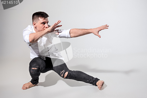 Image of The young man dancing on gray