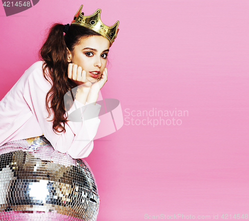 Image of young cute disco girl on pink background with disco ball and cro