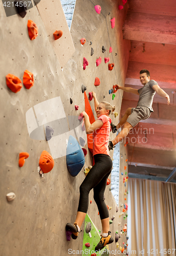 Image of man and woman exercising at indoor climbing gym