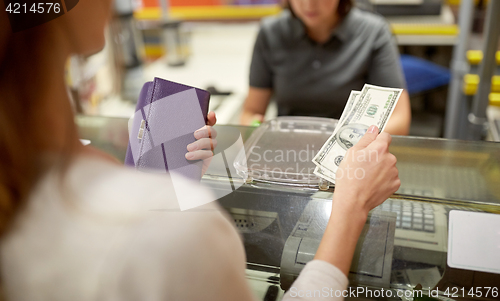Image of woman paying money at store cash register