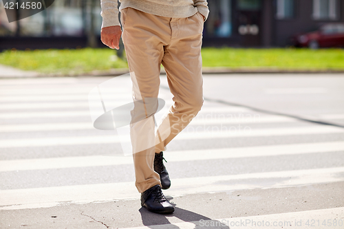 Image of senior man walking along city crosswalk