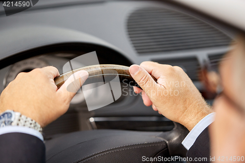 Image of senior businessman hands driving car