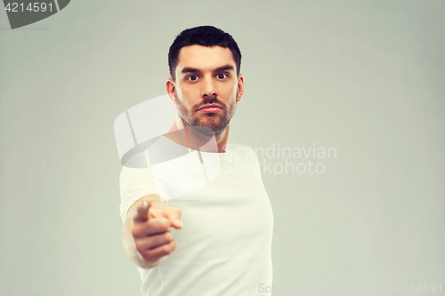 Image of angry man pointing finger to you over gray