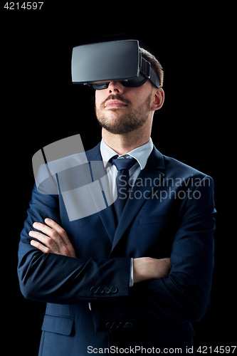 Image of businessman in virtual reality headset over black