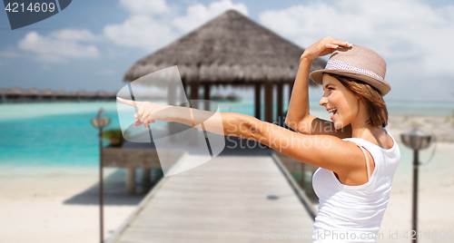 Image of happy young woman in hat on summer beach