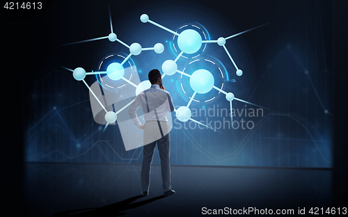 Image of businessman looking at virtual molecule projection