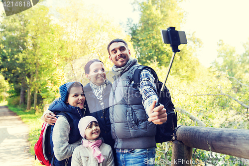 Image of family with backpacks taking selfie and hiking