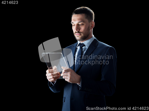 Image of businessman in suit with transparent tablet pc