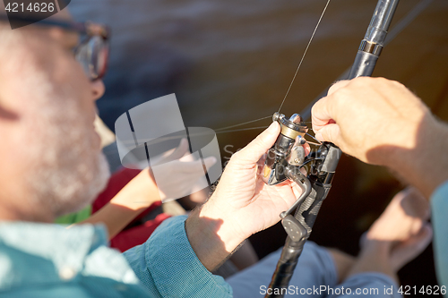 Image of senior man with fishing rod or spinning on river