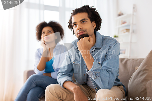 Image of happy couple sitting on sofa at home