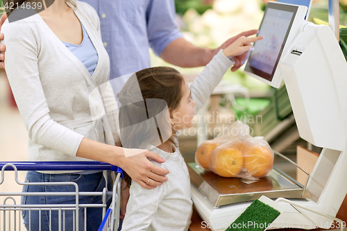 Image of family weighing oranges on scale at grocery store