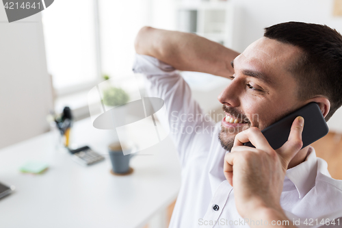 Image of businessman calling on smartphone at office