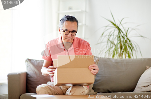 Image of man opening parcel box at home