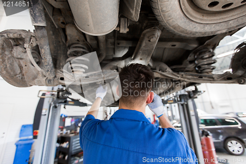 Image of mechanic man or smith repairing car at workshop