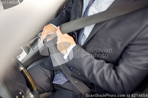 Image of senior businessman fastening car seat belt