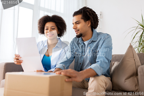 Image of happy couple with parcel box and paper form home