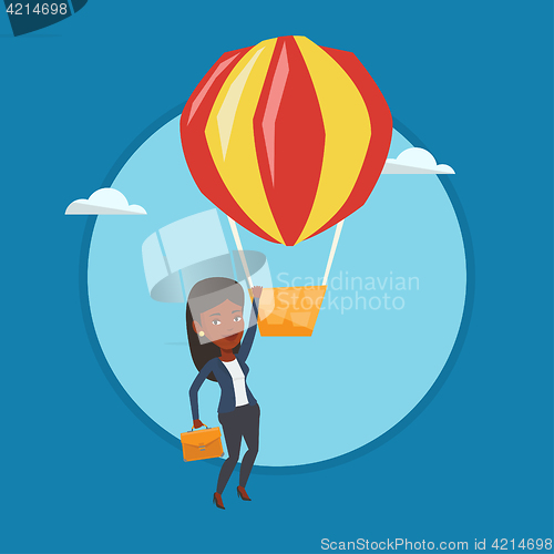 Image of Business woman hanging on balloon.