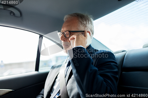 Image of senior businessman calling on smartphone in car