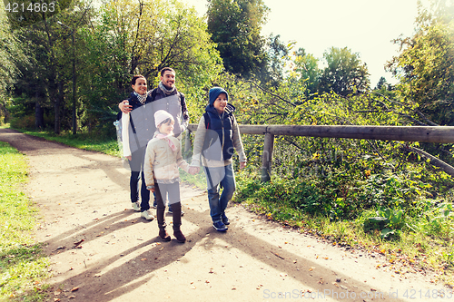 Image of happy family with backpacks hiking in woods