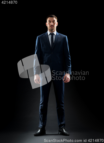 Image of businessman in suit over black