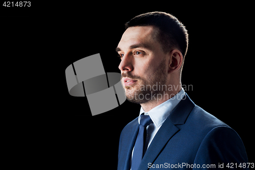 Image of businessman in suit over black