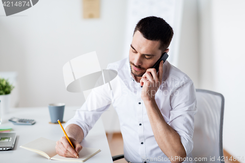 Image of businessman calling on smartphone at office