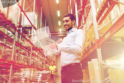 Image of happy businessman with tablet pc at warehouse