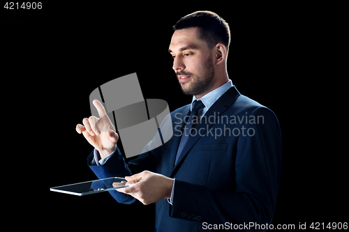 Image of businessman in suit with transparent tablet pc