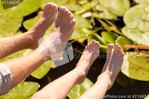 Image of grandfather and grandson feet over river