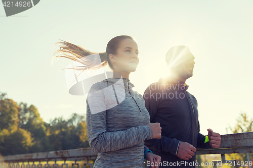 Image of happy couple running outdoors