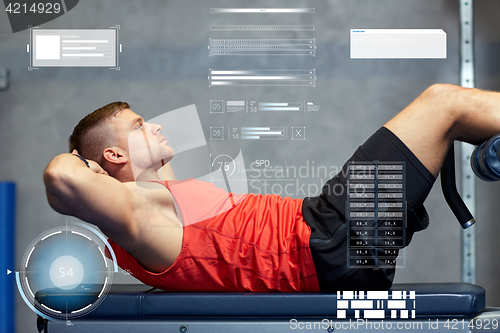 Image of young man making abdominal exercises in gym