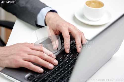 Image of close up of male hands with laptop and coffee cup