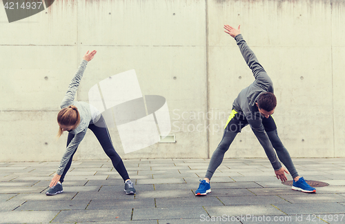 Image of couple stretching on city street