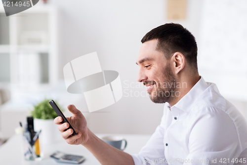 Image of businessman with smartphone at office