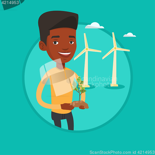 Image of Worker of wind farm holding green small plant.