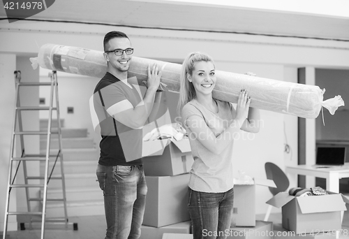 Image of couple carrying a carpet moving in to new home