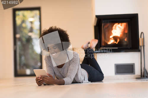 Image of black women using tablet computer on the floor