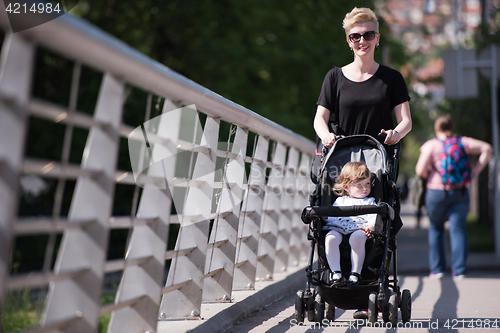 Image of mother pushed her baby daughter in a stroller