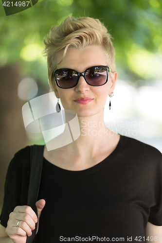 Image of young woman with short blond hair and sunglasses