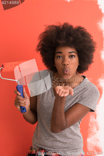 Image of black woman painting wall